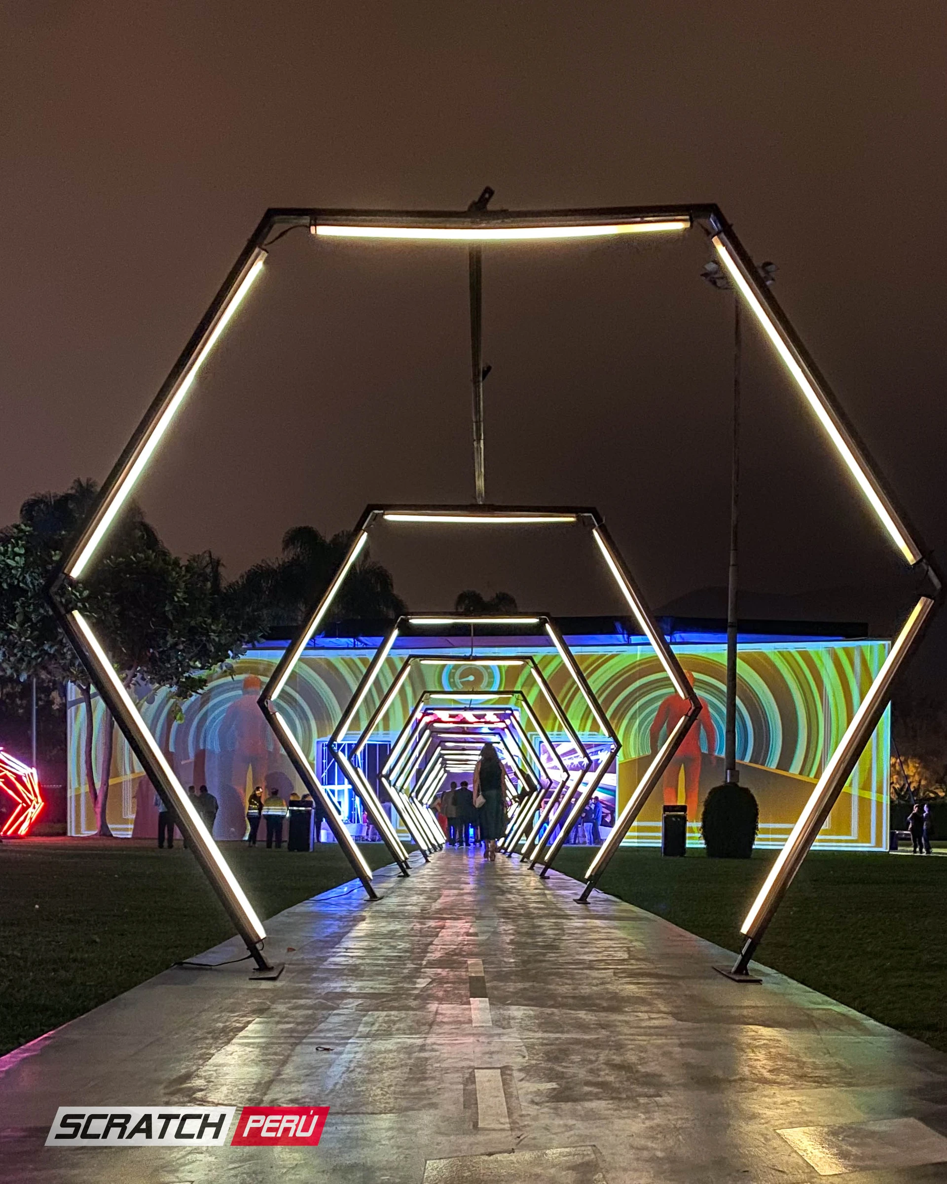 Túnel LED hexagonal blanco: Ambiente luminoso con personas ingresando al evento, creando una atmósfera festiva. - Túnel hexagonal led - scratch perú.