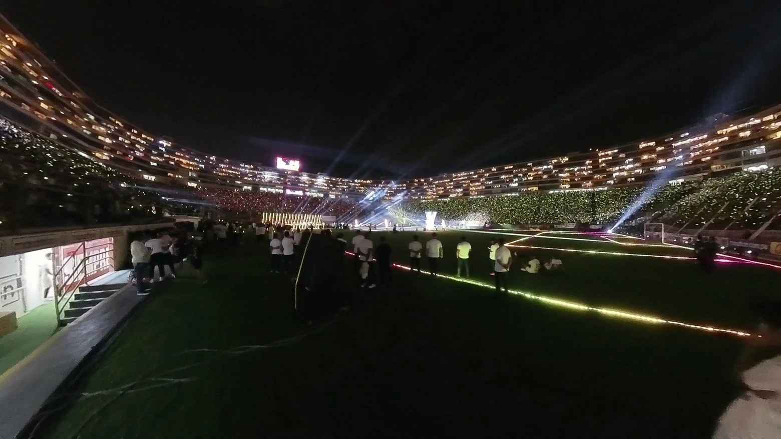 Vista frontal de un estadio de fútbol con el contorno de la estructura delineado por mini píxeles LED de alta resolución, controlados por el software Madrix 5 para crear patrones de luz dinámicos y personalizados - Iluminación espectacular en Noche Crema 2024 con Scratch Perú - scratch perú.