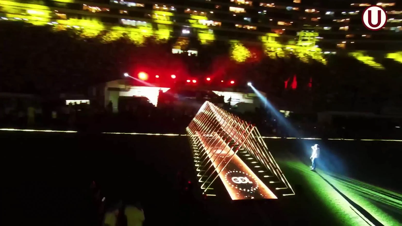 Vista lateral de un túnel triangular formado por tubos LED de 3 metros de altura, que cambian de color y brillo según el ritmo de la música, controlados por el software Madrix 5 - Iluminación espectacular en Noche Crema 2024 con Scratch Perú - scratch perú.