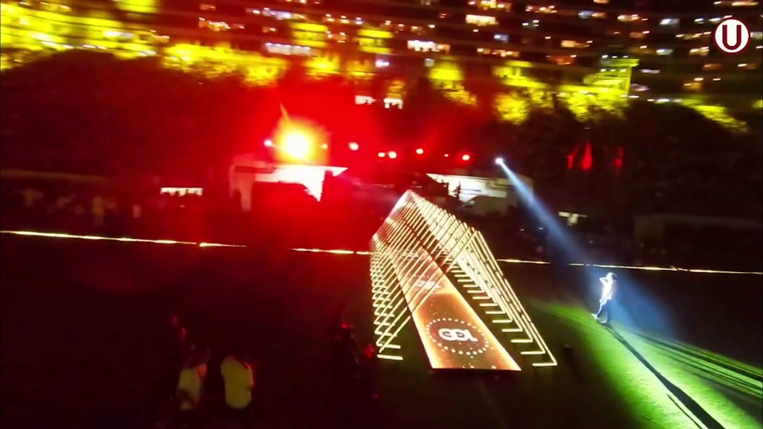 Vista desde el interior de un túnel triangular de tubos LED RGB, que cambian de color y brillo según el movimiento de las personas que pasan por él, controlados por el software Madrix que permite crear efectos visuales interactivos - Iluminación espectacular en Noche Crema 2024 con Scratch Perú - scratch perú.