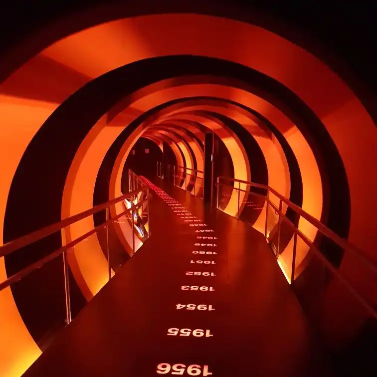 Túnel futurista iluminado con pantallas LED, mostrando un diseño envolvente con iluminación en tonos rojos y negros. Ideal para instalaciones artísticas y experiencias inmersivas.