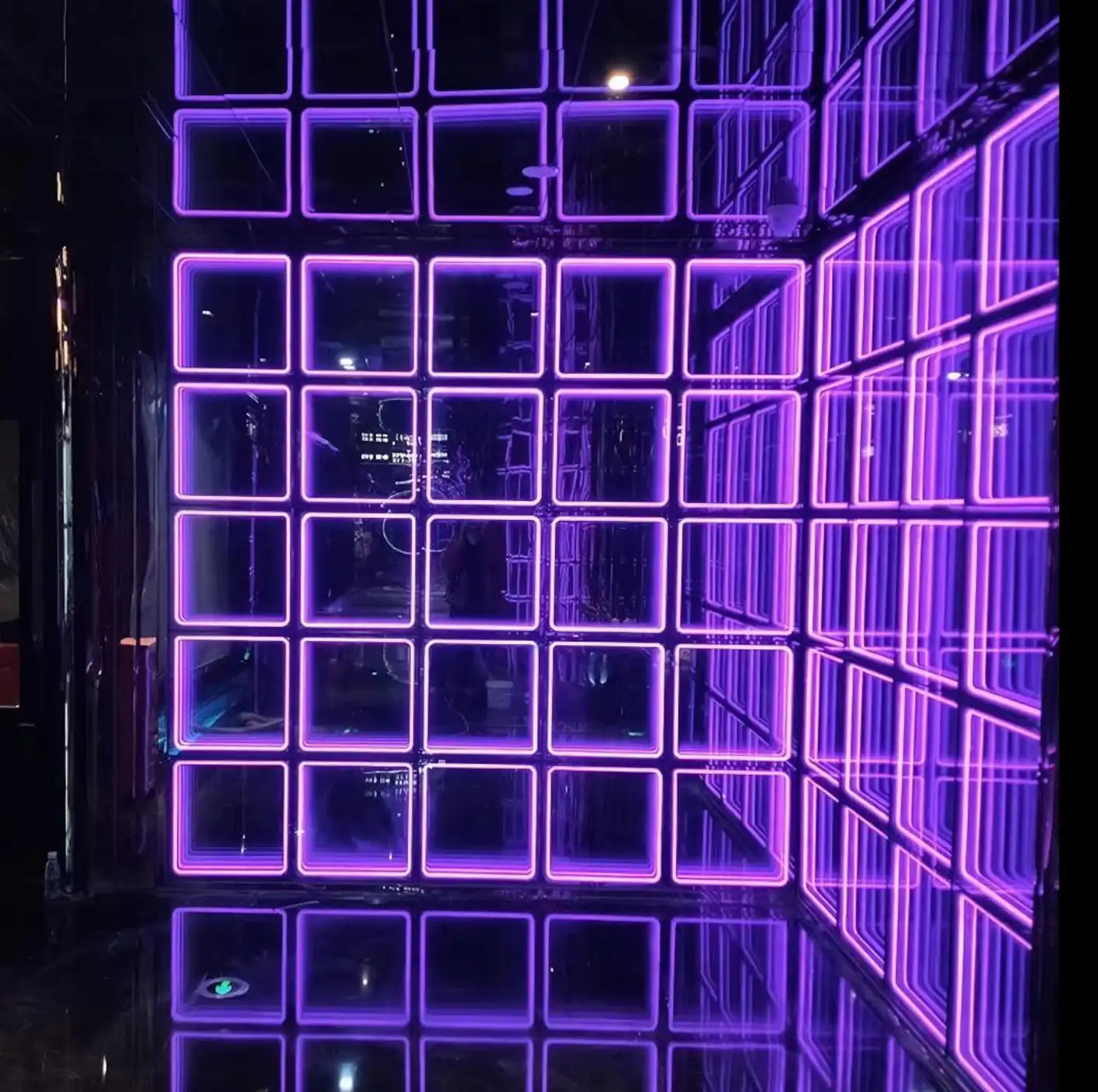 Detalle de esquina con paneles LED Espejo Infinito 3D en tono púrpura Vista de detalle de una esquina revestida con paneles LED Espejo Infinito 3D en tono púrpura, mostrando la profundidad del efecto túnel 3D.
