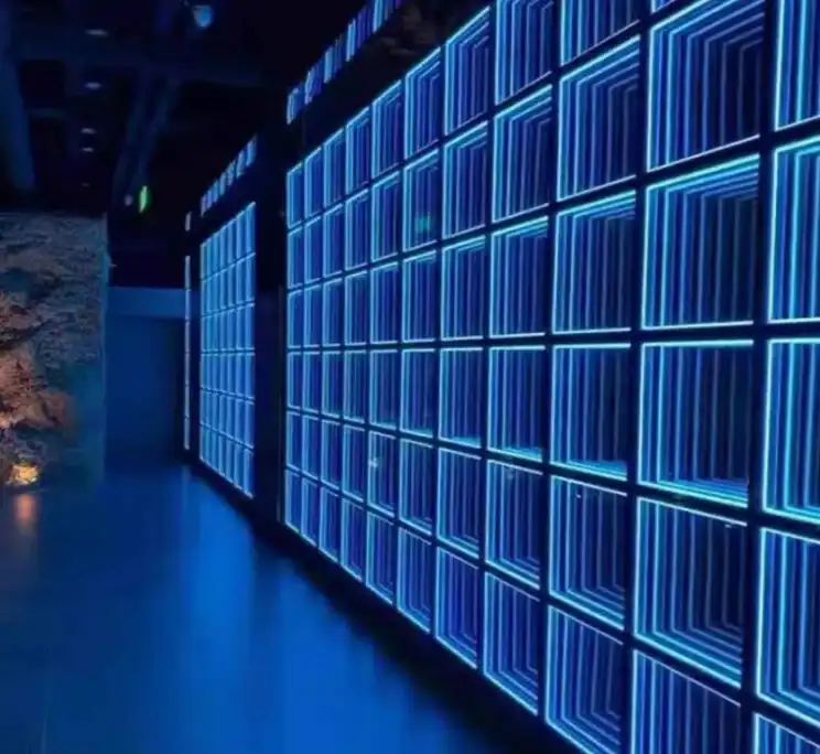 Pasillo decorado con paredes LED Espejo Infinito 3D en tono azul Pasillo interior decorado con dos muros de paneles LED Espejo Infinito 3D en tono azul, piso reflectante y una roca ornamental como acento.