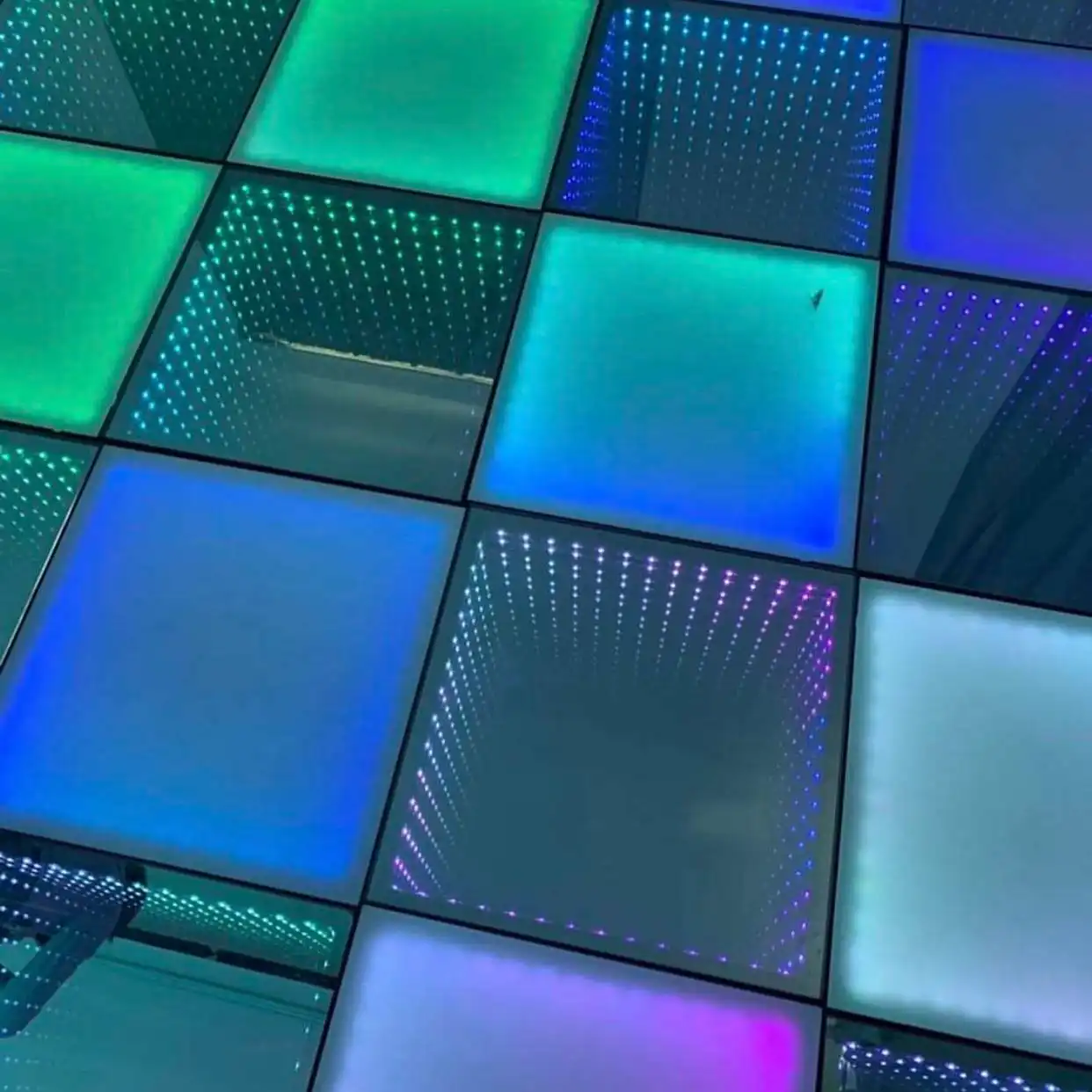 Detalle macro de los paneles LED 3D Infinity Mirror en verde y púrpura Vista de cerca de los paneles de la pista de baile LED 3D Infinity Mirror en tonos verde, azul y púrpura, mostrando la textura del cristal templado.