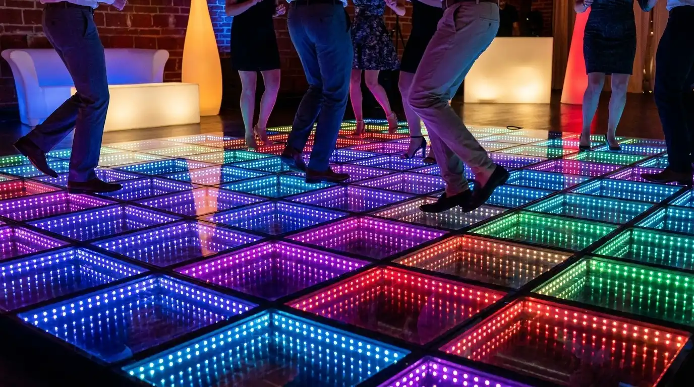 Detalle de invitados bailando sobre la pista LED 3D Infinity Mirror multicolor Detalle de los pies de los invitados bailando sobre la pista de baile LED 3D Infinity Mirror multicolor en un ambiente de lounge.