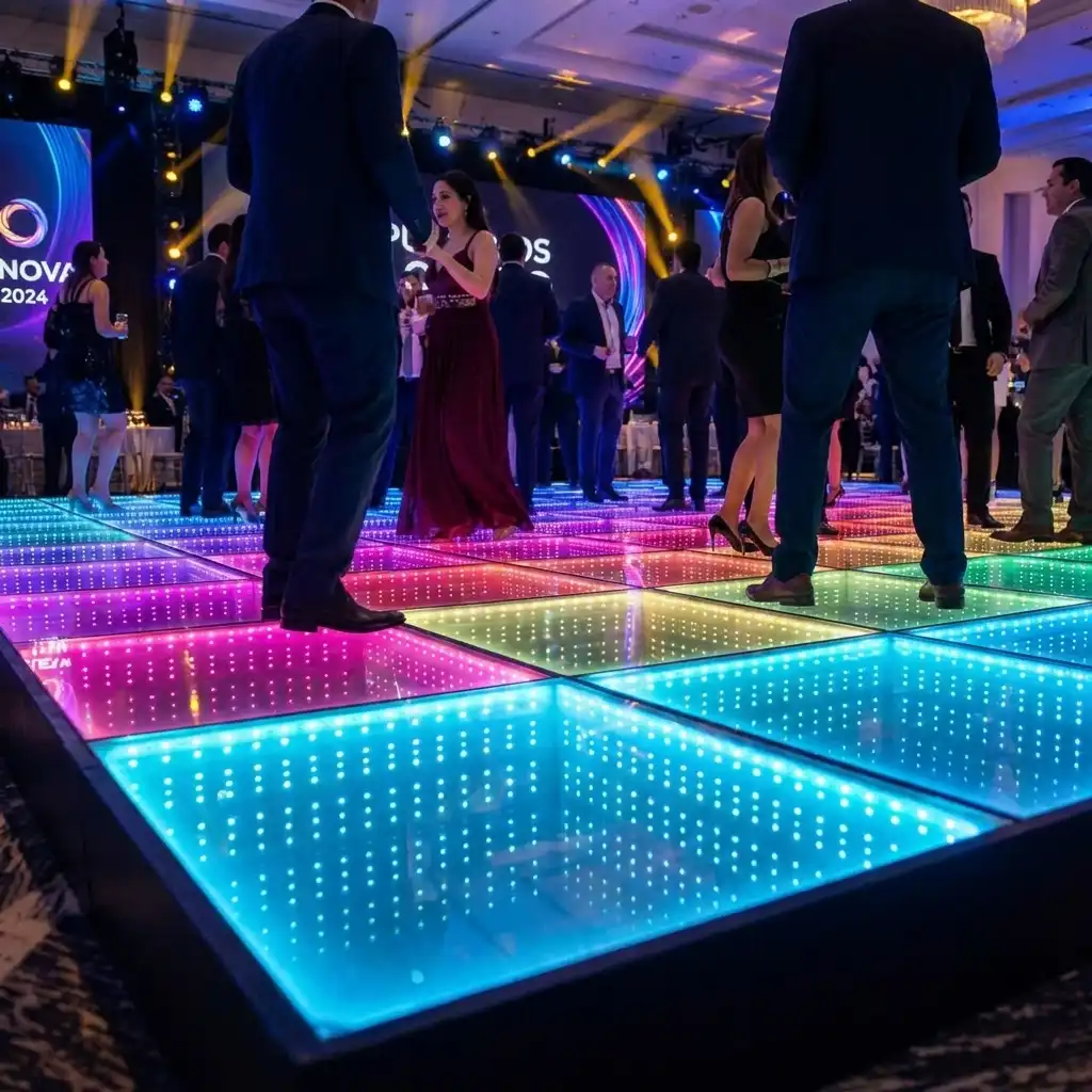 Invitados de gala conversando y bailando sobre la pista de baile LED 3D Infinity Mirror multicolor durante el evento corporativo INNOVA 2024.