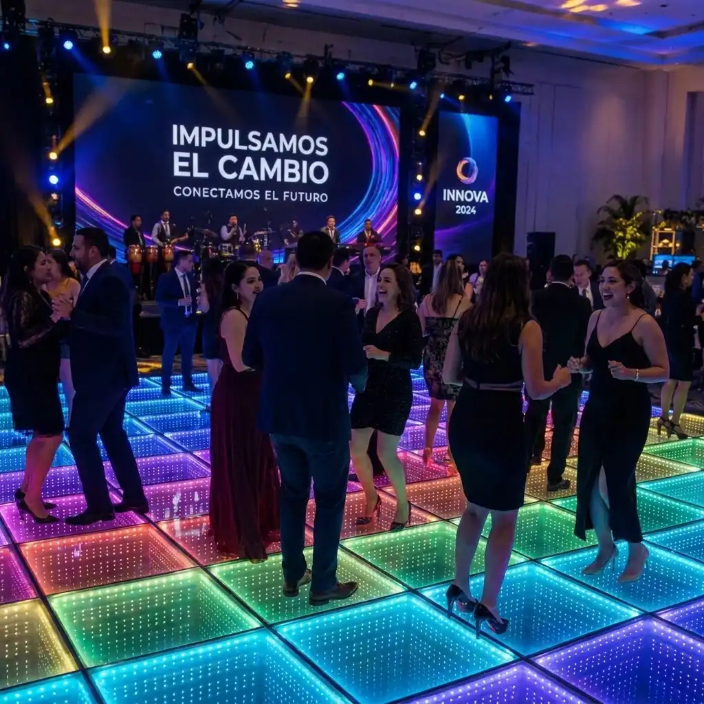 Invitados riendo y bailando sobre la pista de baile LED 3D Infinity Mirror multicolor bajo la pantalla Impulsamos el Cambio del evento INNOVA 2024.