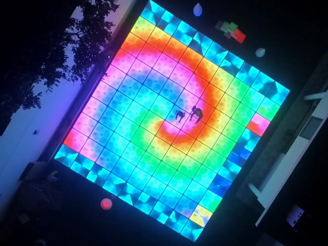 Pista de baile LED con efectos visuales que mezclan colores vibrantes en patrones de espiral, ideal para animar el ambiente de fiestas y eventos.