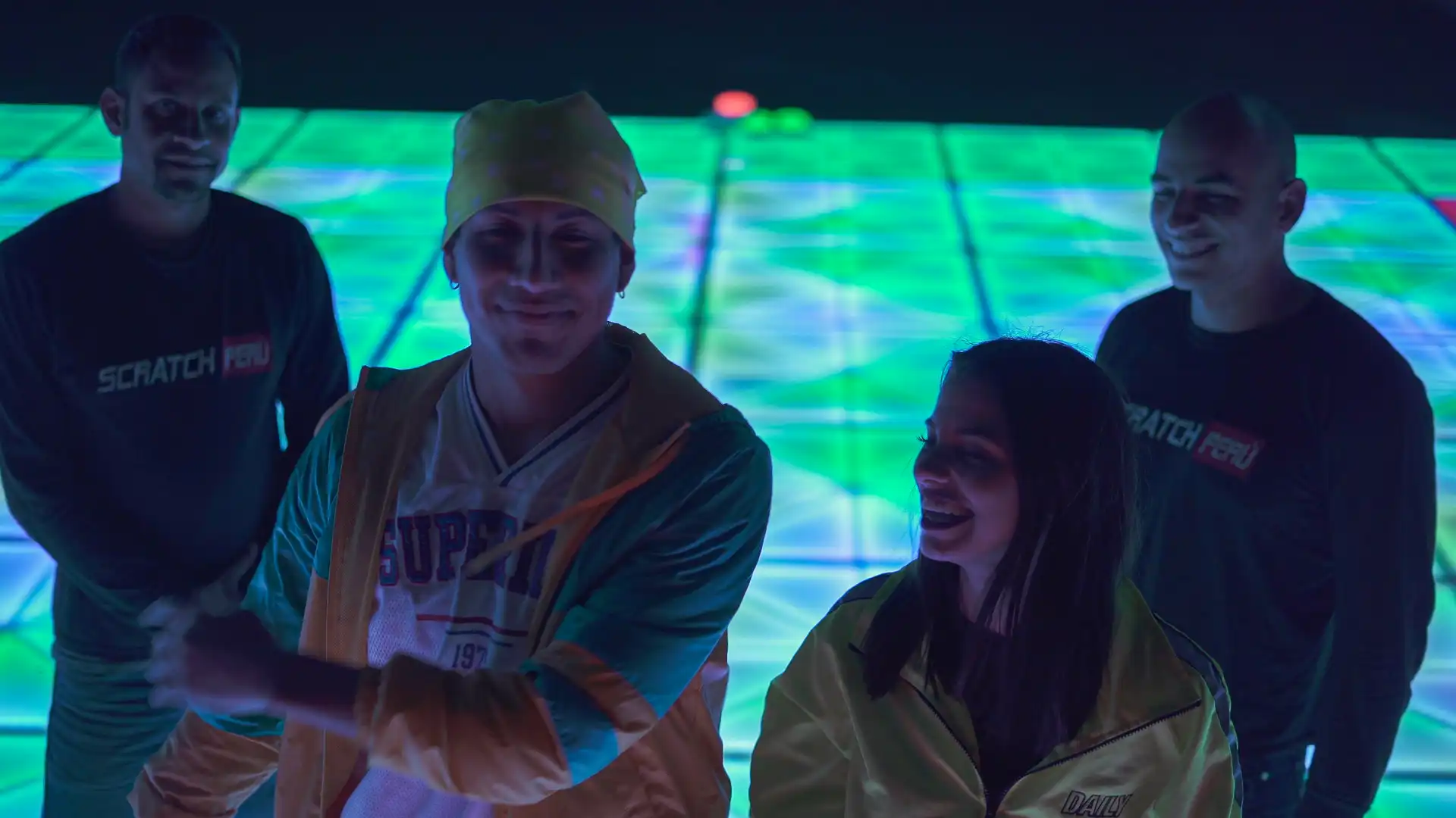 Dos personas bailando en una pista de baile LED al aire libre, con iluminación nocturna vibrante.