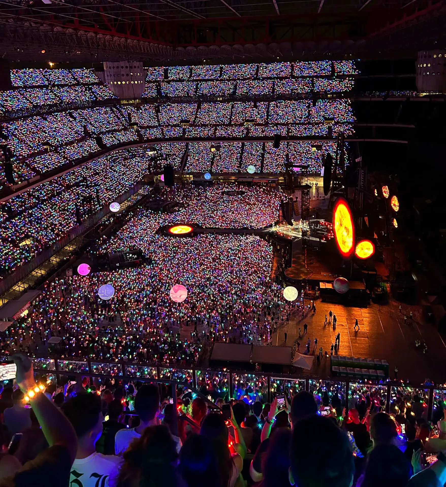 Multitud disfrutando de un espectáculo en vivo, con pulseras LED sincronizadas creando un ambiente inmersivo.