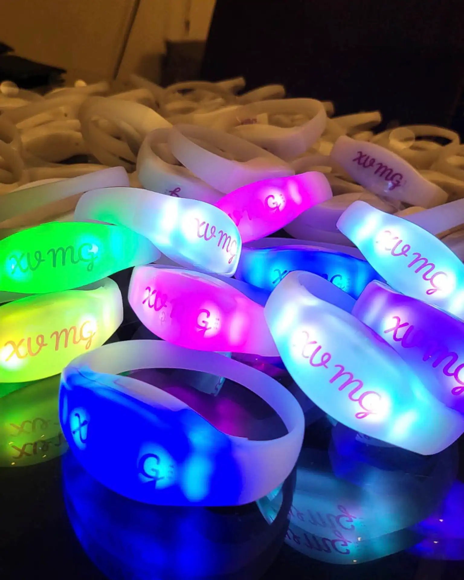 Pulseras LED multicolores personalizadas con iniciales, perfectas para eventos como fiestas de XV años o bodas.