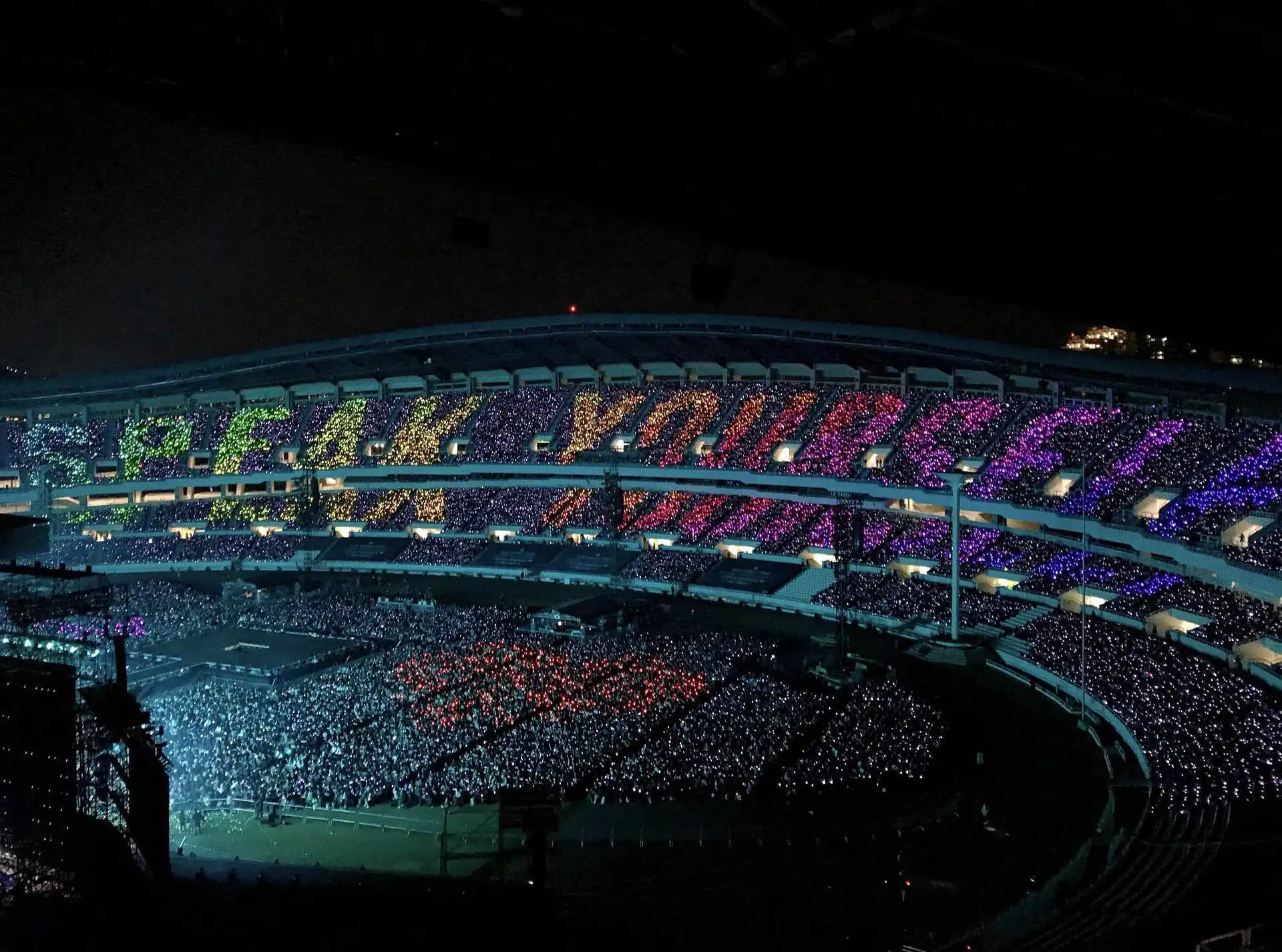 Imagen de un estadio donde las luces LED forman un mensaje visual 'Speak Yourself' en las gradas.