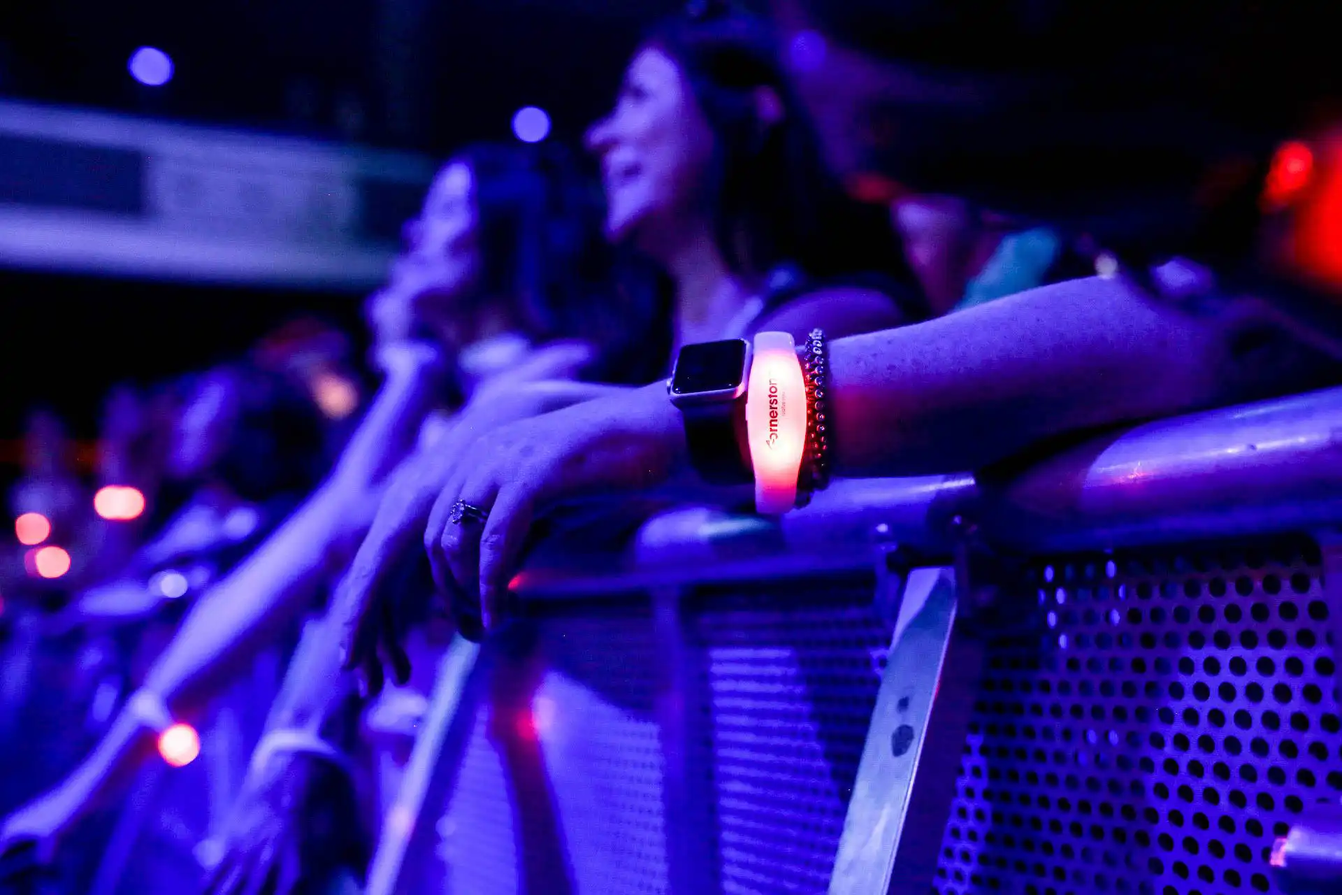 Primer plano de una pulsera LED iluminada en rojo durante un concierto, perfecta para mejorar la interacción en eventos.