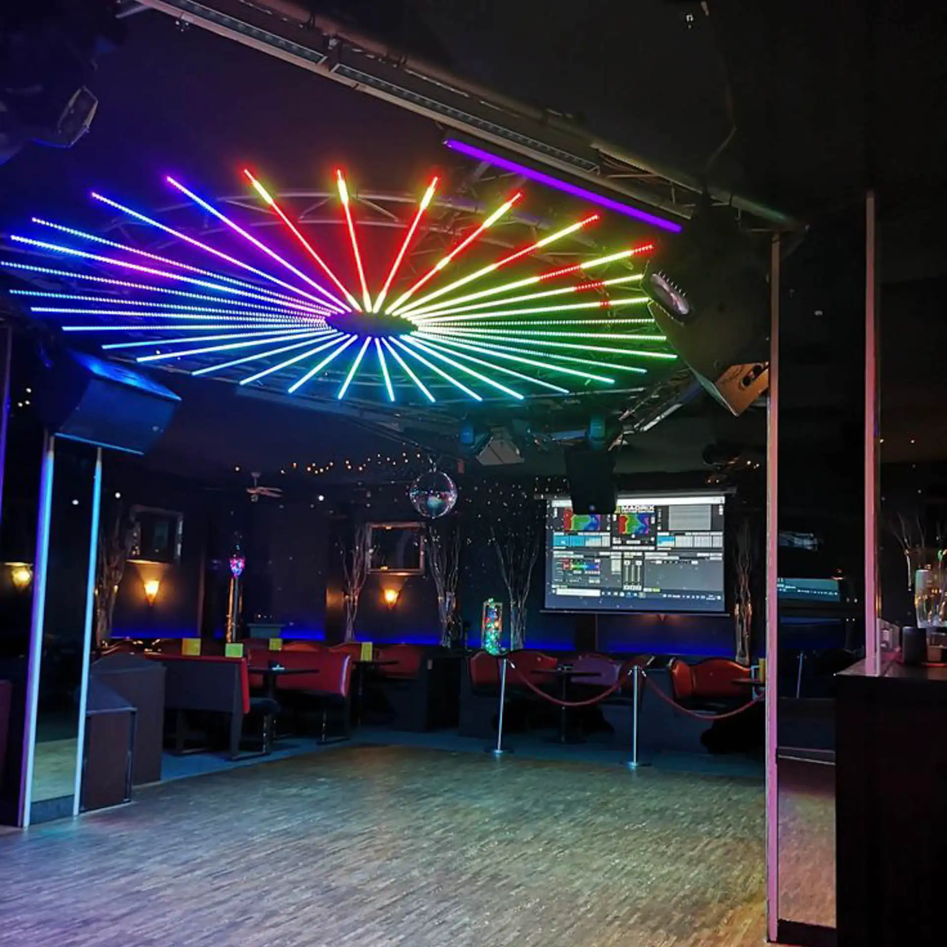 Elegante instalación de techo en un club nocturno, utilizando tubos LED RGB 360 grados controlados por ArtNet. Las luces en forma de rueda de colores crean una atmósfera vibrante y moderna, ideal para animar cualquier espacio de entretenimiento.