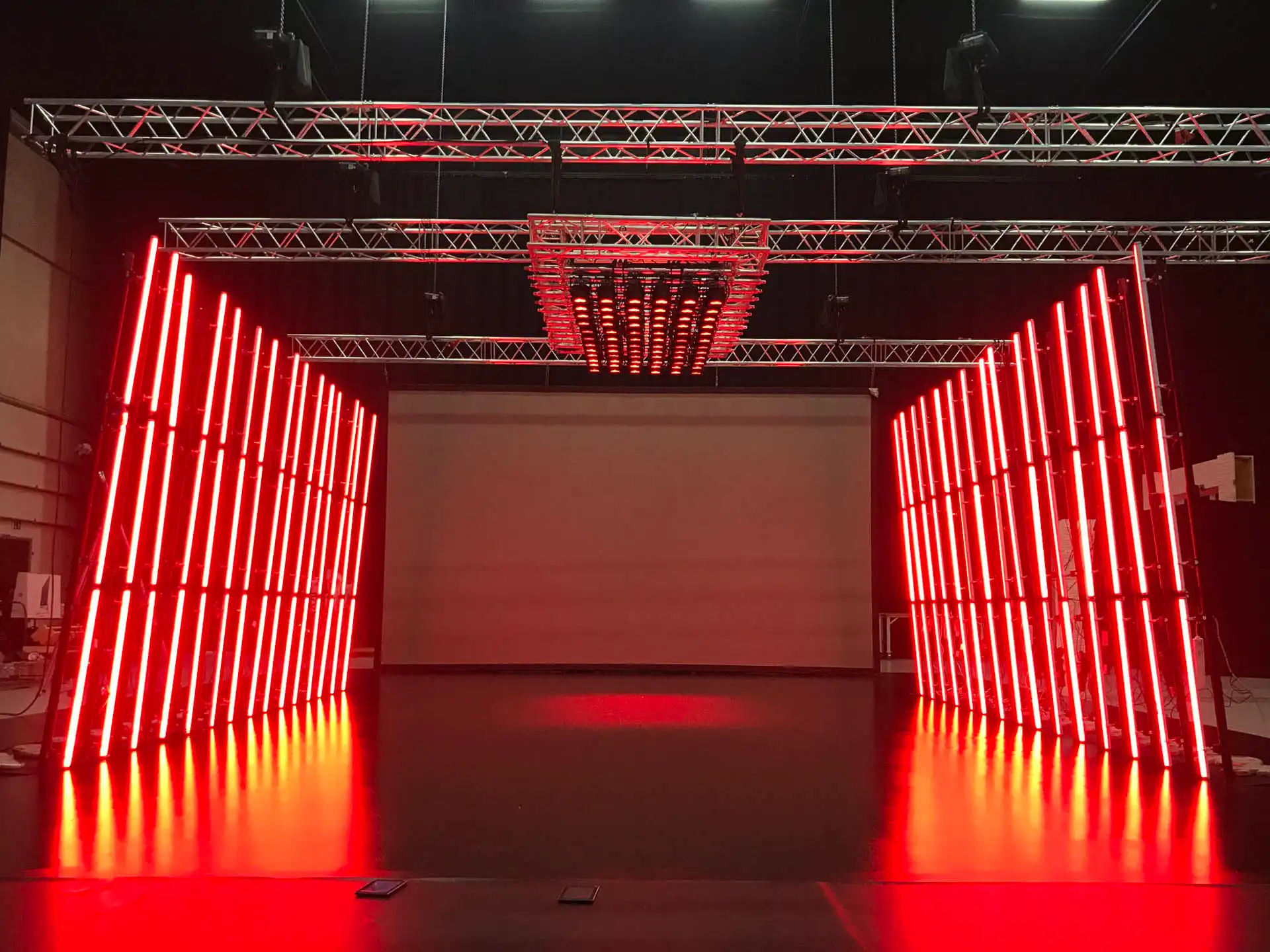 Impresionante escenario de producción con iluminación LED RGB 360 grados controlada por ArtNet. Las luces rojas intensas crean un ambiente dramático, perfecto para producciones audiovisuales y eventos en vivo.