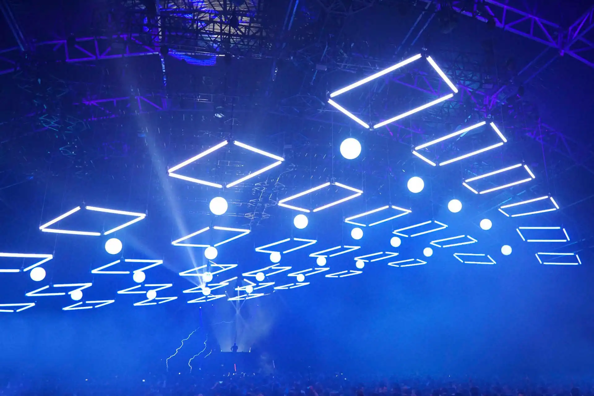 Instalación de techo con tubos LED RGB 360 grados controlados por ArtNet en un evento masivo. Las luces cuadradas azules crean un efecto visual deslumbrante sobre la multitud, mejorando la atmósfera del concierto.