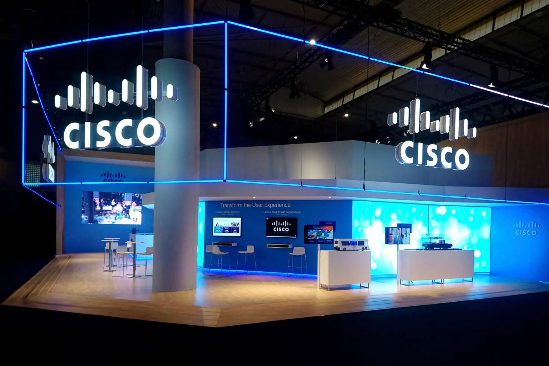 Stand de exhibición de Cisco con iluminación LED RGB 360 grados controlada por ArtNet. Las luces azules delinean la estructura, proporcionando un diseño moderno y atractivo en la feria tecnológica.